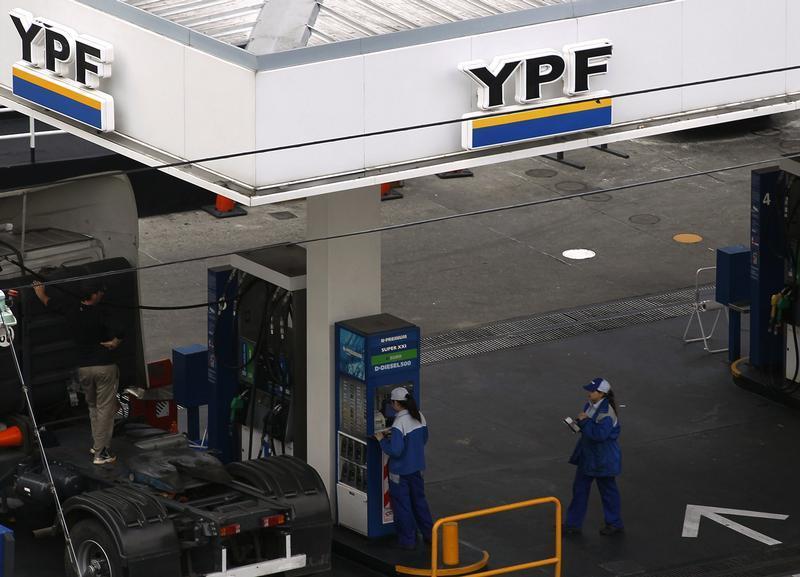 Employees work at a YPF gas station in Buenos Aires